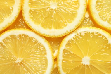 Arka plan olarak sulu limon dilimleri, üst görünüm. Narenciye