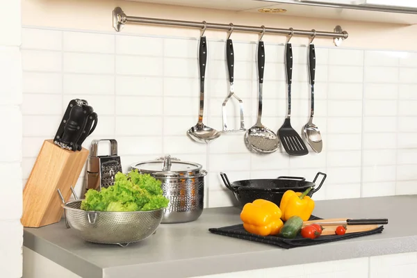 Uppsättning av rena grytor, redskap och produkter på bord i modernt kök — Stockfoto
