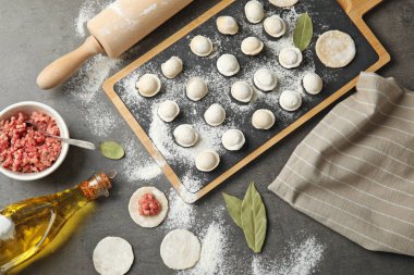 Gri arka planda ham köfte ve malzemeler ile düz yatıyordu kompozisyon. Pişirme süreci