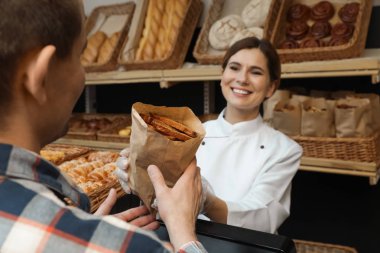 Baker veren müşteri kağıt çanta ile pasta içinde mağaza