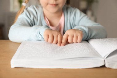 Parmaklık masada Braille yazılmış kör çocuk okuma kitabı, çekim