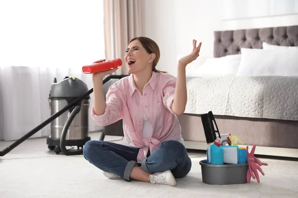 Счастливая женщина веселится во время уборки спальни — стоковое фото