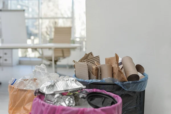 Latas de lixo completas no escritório moderno, espaço para texto. Reciclagem de resíduos — Fotografia de Stock