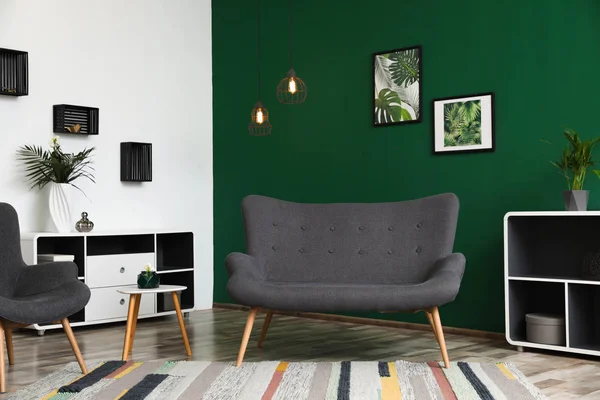 Современный интерьер гостиной стильный диван возле зеленой стены — стоковое фото