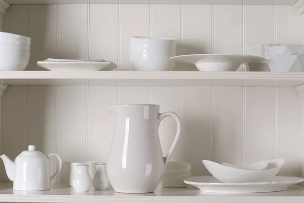 Elegante porta oggetti con diversi stoviglie in ceramica a casa — Foto Stock