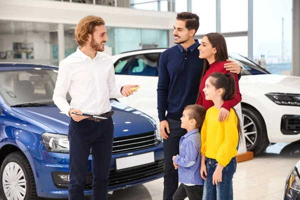 Vendedor de carros trabalhando com a família na concessionária — Fotografia de Stock