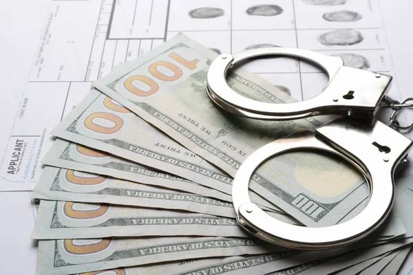 Dinero, esposas y hojas de registro de huellas dactilares, primer plano. Investigación penal — Foto de Stock