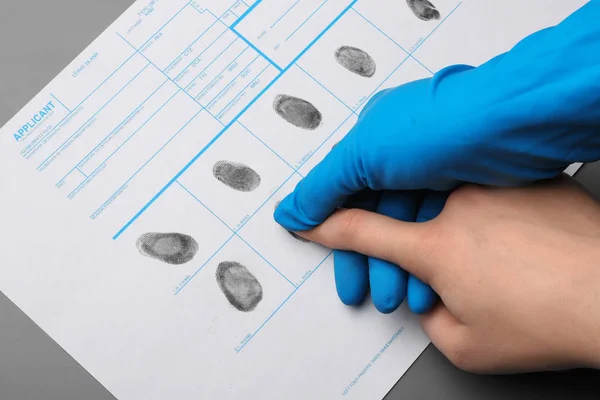 Onderzoeker voor het nemen van vingerafdrukken van verdachte aan tafel, close-up. Criminele expertise — Stockfoto