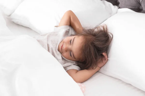 Roztomilá holčička spí v útulné posteli — Stock fotografie