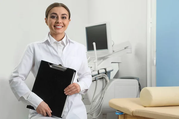 Sonographe professionnel avec presse-papiers près de la machine ultrasonore moderne en clinique — Photo