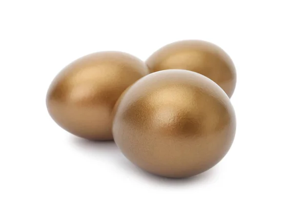 Tři lesklé zlaté vejce na bílém pozadí — Stock fotografie