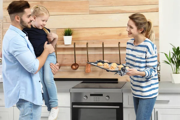 Jovem tratando sua família com forno caseiro assado biscoitos na cozinha — Fotografia de Stock