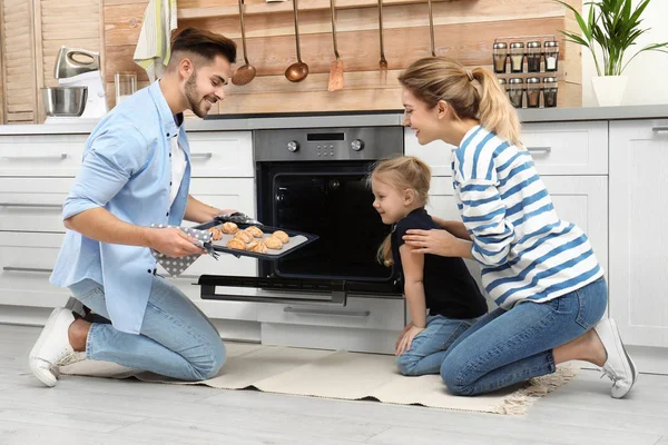 Feliz família assar biscoitos no forno em casa — Fotografia de Stock