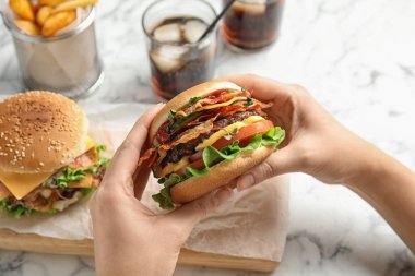 Pastırmalı lezzetli burgeri olan kadın servis masasında, yakın plan.