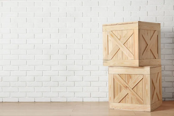 Wooden crates on floor near brick wall, space for text — Stockfoto