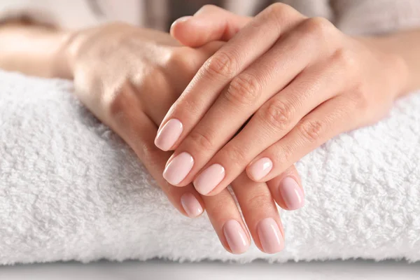 Vista de cerca de hermosas manos femeninas en la toalla. Tratamiento de spa — Foto de Stock