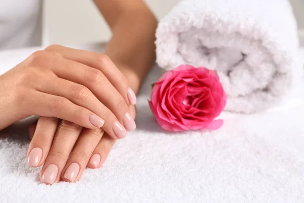 Крупный план красивых женских рук и розы на полотенце, место для текста. Лечение — стоковое фото