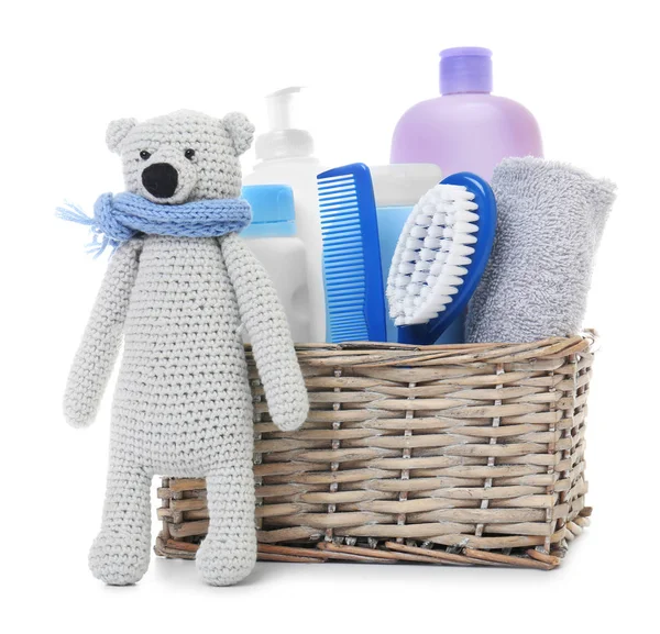 Wicker basket with baby cosmetic products and knitted bear isolated on white — 스톡 사진