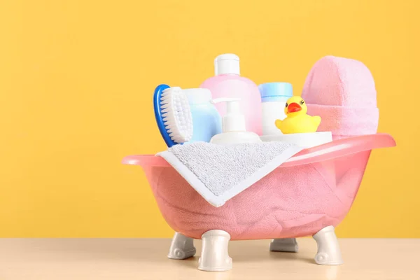 Produtos cosméticos do bebê, brinquedo e toalha na mesa contra fundo de cor — Fotografia de Stock