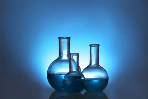 色の背景に液体が付いている実験室のガラス製品。ソリューション化学 — ストック写真