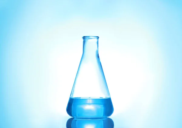 Laborkolben mit Flüssigkeit auf farbigem Hintergrund. Lösungschemie Stockbild