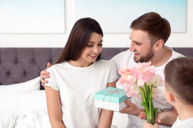 Baba ve oğul yatak odasında annemi tebrik ediyor. Mutlu anneler günü