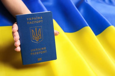 Ukrayna pasaportu taşıyan bir kadın ulusal bayrağın üzerinde, mesaj için yeri olan bir yere yakın çekim yapıyor. Uluslararası ilişkiler