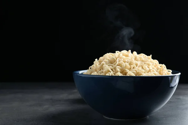 Cuenco de fideos calientes en la mesa sobre fondo negro. Espacio para texto —  Fotos de Stock