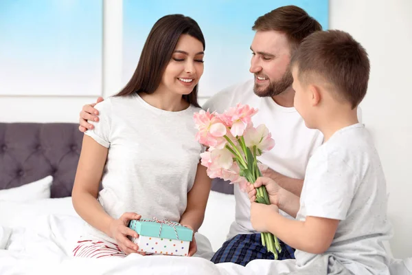 Vader en zoon feliciteren mam in de slaapkamer. Gelukkige Mother's Day — Stockfoto