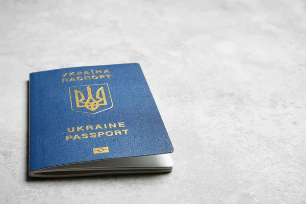 Украинский загранпаспорт на сером фоне, крупным планом с пробелами для текста. Международные отношения — стоковое фото