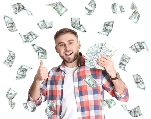 Portrait of happy young man with money and flying American dollars on white background — Stock Photo, Image