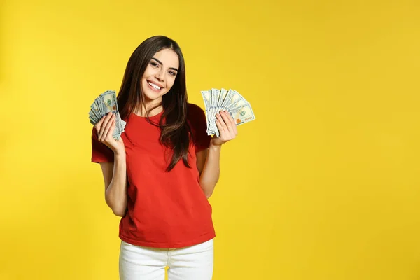 Young woman with money on color background. Space for text