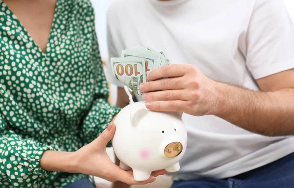 Young couple with piggy bank and money, closeup — 스톡 사진