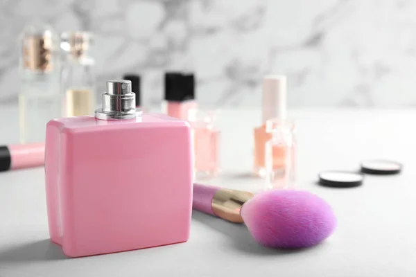 Пляшка парфумів і косметичної щітки на столі на мармуровому фоні. Простір для тексту — стокове фото