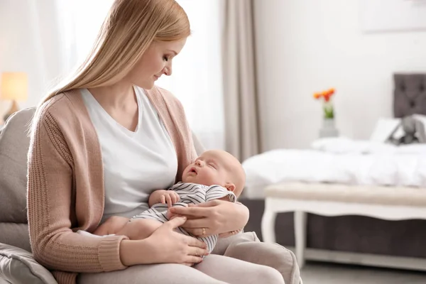 Anya vele kis baba ül karosszékben otthon — Stock Fotó
