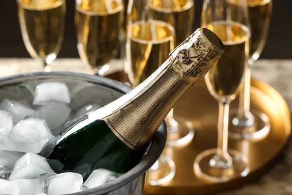 Flaska champagne i hink med isbitar på bordet, närbild — Stockfoto