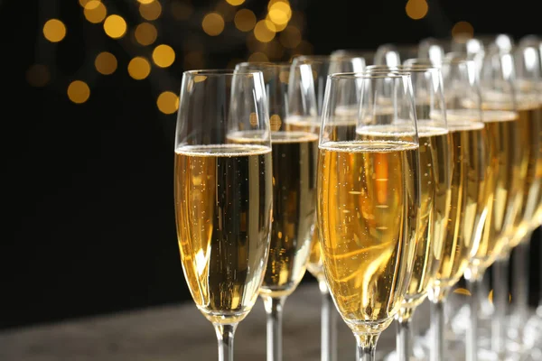Glazen Champagne tegen vervaagde lichten, close-up. Bokeh-effect — Stockfoto