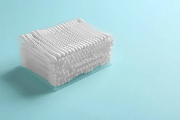 Contenitore in plastica con tamponi di cotone su sfondo colore. Spazio per testo — Foto Stock
