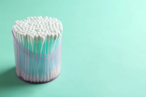Plastic container with cotton swabs on color background. Space for text — Stock Photo, Image