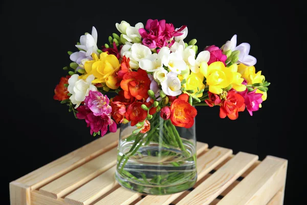 Букет весняних квітів фрезії у вазі на темному фоні — стокове фото