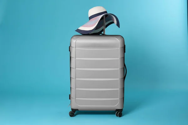 Stilvoller Koffer mit Hut auf farbigem Hintergrund — Stockfoto