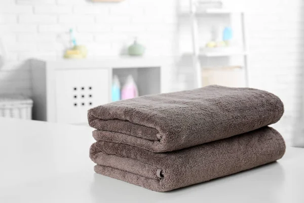 Montón de toallas frescas en la mesa en el baño. Espacio para texto — Foto de Stock