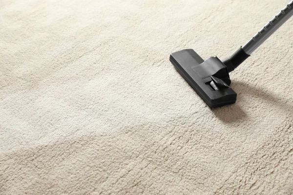 Menghapus kotoran dari karpet ringan dengan vacuum cleaner. Ruang untuk teks — Stok Foto