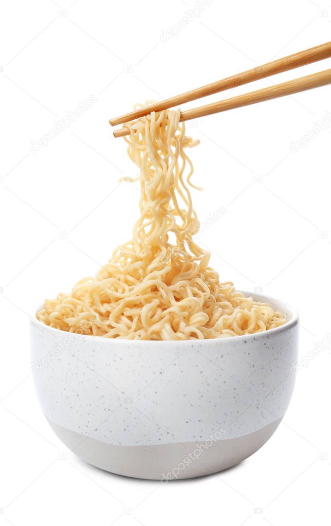 Chopsticks with tasty instant noodles over bowl isolated on white
