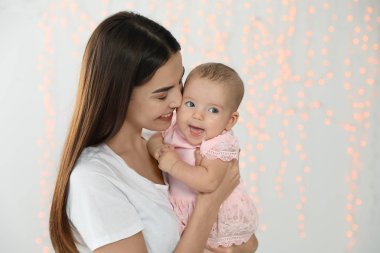 Bulanık ışıklara karşı bebeği ile mutlu anne portresi. Metin için alan