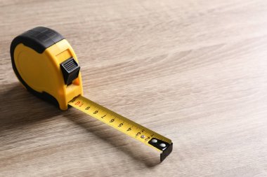 Ahşap arka planda metal ölçüm bandı. Metin için alan