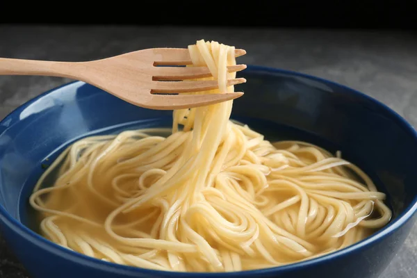 Noodle Dish eten met vork op tafel, close-up — Stockfoto