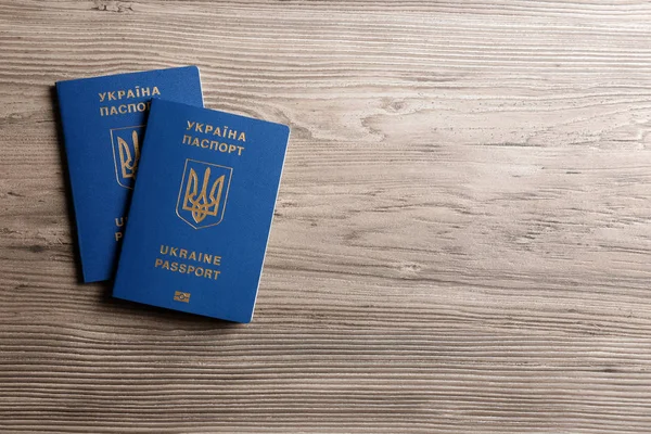 Украинские загранпаспорта на деревянном фоне, вид сверху с пробелами для текста. Международные отношения — стоковое фото