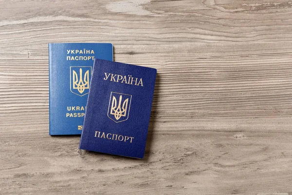 Украинские паспорта на деревянном фоне, вид сверху с пробелами для текста. Международные отношения — стоковое фото