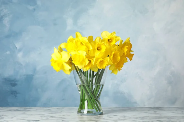 Ramillete de narcisos en jarrón sobre mesa sobre fondo de color. Flores frescas de primavera —  Fotos de Stock
